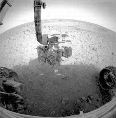 Le bras de Spirit, bardé d'instruments, s'apprête à examiner le sol martien